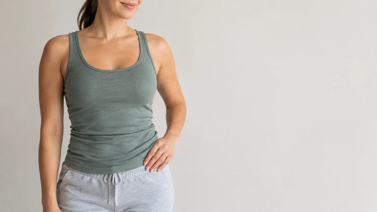 Personne adulte en tenue confortable, debout dans une posture naturelle, la main près de la taille.